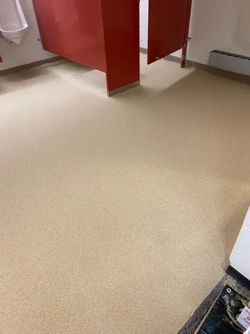 Beige flake epoxy in a commercial restroom with red stall partitions — a Greater Cincinnati job