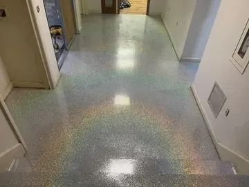 Glitter flake epoxy catching the light in a hallway — a Greater Cincinnati job